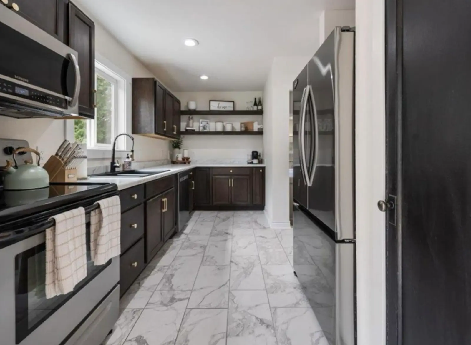 Kitchen remodel by Atlas Construction with dark wood cabinets and marble-look tile